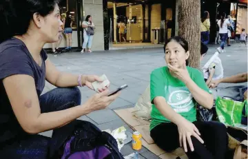  ?? — Reuters ?? We Remit volunteer Jona de Cuia chats with Joslyn Pimentero, a domestic helper, at the financial Central district in Hong Kong, China.