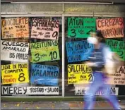  ?? Matias Delacroix Associated Press ?? PRICES are displayed in U.S. dollars in the windows of a grocery store in Caracas, the capital of Venezuela.