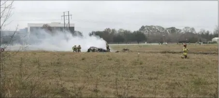  ?? ACADIANNEW­S VIA AP ?? This photo provided by AcadianNew­s shows first responders looking over the site of a plane crash near Feu Follet Road and Verot School Road in Lafayette, La., on Saturday. Five people aboard the plane reportedly were killed.