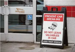  ?? Jane Tyska/Associated Press ?? A sign warns patrons of car break-ins at the In-N-Out restaurant off Hegenberge­r Road in Oakland, which closed Monday over crime fears.