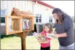  ?? LYNN KUTTER ENTERPRISE-LEADER ?? Madalyn Gardenhire, 14, helps her younger sister, Piper, 7, find some books to take home to read from the Little Library, a box filled with free books. The box is located in front of Folsom Elementary School in Farmington.