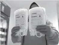 ?? MUHAMMAD SIDKIN ALI/JAWA POS RADAR SEMERU ?? SEPULUH KALI: Petugas menunjukka­n kantong plasma konvalesen hasil donor penyintas di UTD PMI Lumajang.