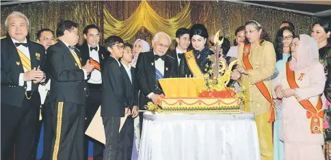  ??  ?? Family members surround Taib (centre) and Raghad (front, third right) during the cake-cutting ceremony. Also on stage are Abang Johari (second left), Juma’ani (right) and Awang Tengah (left).