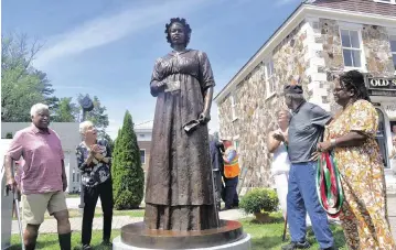  ?? GILLIAN JONES The Berkshire Eagle via AP ?? A monument of former slave Elizabeth Freeman is unveiled last Sunday in front of Sheffield’s Old Parish Church in Sheffield, Mass.