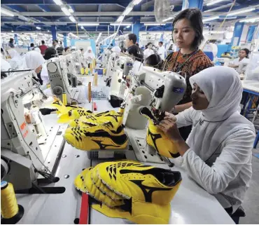  ?? Foto: AFP/Adek Berry ?? Sportschuh­produktion in Indonesien