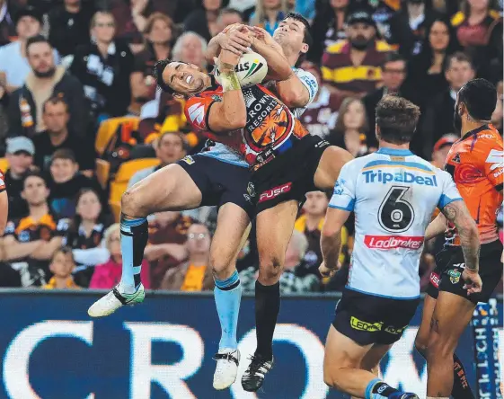  ??  ?? Anthony Don takes to the air against Melbourne’s Billy Slater during the game between the Titans and the Storm at Suncorp Stadium. Picture: ADAM HEAD