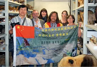  ??  ?? Le 15 juillet 2014, Luo Weixiao fait don du drapeau qu’il a fait tamponner tout au long de son périple au Muséum national d’histoire naturelle de France.