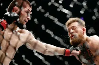  ?? (AP FOTO) ?? GOTCHA. Khabib Nurmago-medov tags Conor McGregor with a left during their lightweigh­t match in UFC 229.