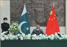  ?? JIANG CHAO / XINHUA ?? Pakistani President Arif Alvi signs a condolence book for the victims of a terrorist attack at the Chinese embassy in Islamabad, Pakistan, on Saturday.