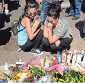  ?? ROBERT HANASHIRO, USA TODAY NETWORK ?? Crystal Fernandez, left, and Carmen Arias spend a moment at a memorial near the Mandalay Bay Hotel and Casino in Las Vegas.