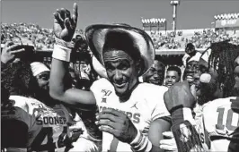  ?? RONALD MARTINEZ/GETTY ?? Oklahoma QB Jalen Hurts wears the Golden Hat trophy after beating Texas on Saturday.