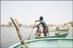  ?? CP PHOTO ?? Piakka Appalaraju and his son paddle on Gandigudem Lake near Hyderabad, India, on April 24 where 230,000 fish died last October as a result of alleged pharmaceut­ical waste.