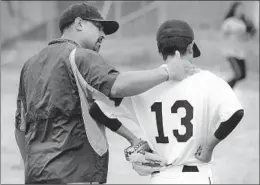  ??  ?? COACH Robert Galvan consoles Mike Morales, one of only 11 players on the Muir varsity, after the third baseman committed an error against Pasadena.