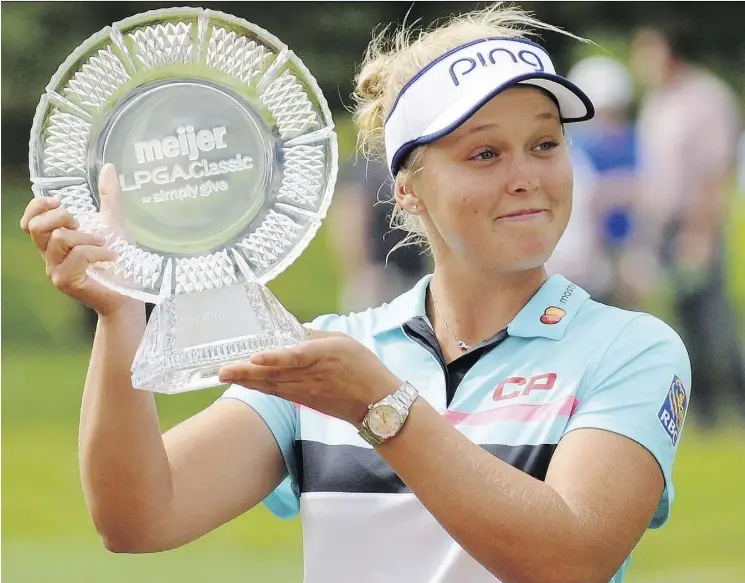  ?? CORY OLSEN/THE ASSOCIATED PRESS ?? Brooke Henderson with the winner’s trophy after winning the Meijer LPGA Classic by two strokes Sunday at Blythefiel­d Country Club in Grand Rapids, Mich.