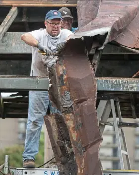  ??  ?? Mayor Shawn Reed lowers a rotted part of the passenger canopy.