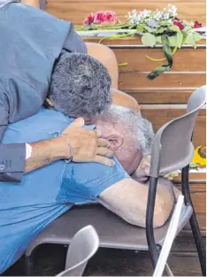  ?? Foto: Massimo Percossi, dpa ?? Zwei Männer trauern am Samstag bei den 35 Särgen von Erdbebenop­fern, die in der Sporthalle des Ortes Ascoli Piceno aufgestell­t wurden.