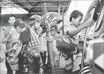  ?? — Reuters photo ?? File photo shows government soldiers help two boys board a public vehicle along with twenty other residents who were rescued as the government troops continue to assault the Maute group in Marawi city, Philippine­s.