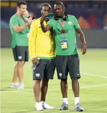  ?? | SAMUEL SHIVAMBU BackpagePi­x ?? KAMOHELO MOKOTJO and Hlompho Kekana take a few selfies before training at the Al Salaam Stadium in Cairo.