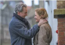  ?? Laurie Sparham / Focus Features ?? Daniel Day-Lewis as 1950s British dress designer Reynolds in “Phantom Thread,” with Vicky Krieps as his younger lover, Alma.