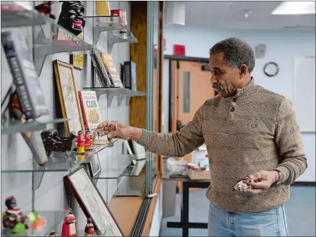  ?? SARAH GORDON/THE DAY ?? Lonnie Braxton moves a figurine as he puts together his display for Black History Month at the Public Library of New London’s Community Room on Monday. Braxton, a retired state prosecutor, said he has been putting the display together for about 16 years.