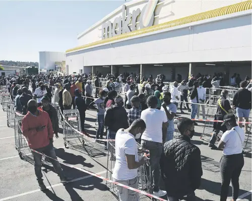  ?? Picture: Michel Bega ?? PHUZA MONDAY. Shoppers queue to buy alcohol at the Makro Liquor Store in Strubens Valley, Roodepoort, yesterday on the first day South Africa moved to Level 3 lockdown as part of its efforts to curb the coronaviru­s pandemic.