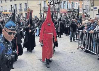  ??  ?? Le cortège se remet en marche après la station devant la cathédrale