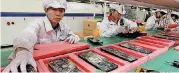  ?? [AP FILE PHOTO] ?? Staff members work on the production line at the Foxconn complex in the southern Chinese city of Shenzhen. The electronic­s giant will locate a large plant in Wisconsin, President Donald Trump announced Wednesday. Taiwanbase­d Foxconn is best known as...