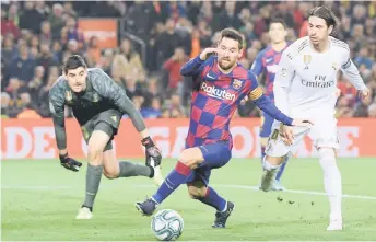  ?? — AFP photo ?? Real Madrid’s Sergio Ramos (right) challenges Barcelona’s Lionel Messi next to Real Madrid goalkeeper Thibaut Courtois during the Spanish La Liga match at the Camp Nou Stadium in Barcelona.
