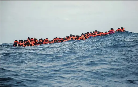  ?? SANTI PALACIOS / AP ?? Un grupo de migrantes en una precaria embarcació­n esperando a ser rescatados por Proactiva Open Arms cerca de Libia, el pasado 25 de julio