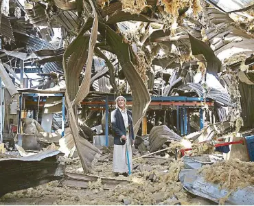  ?? AP ?? In this file photo, a man stands among the rubble of the Alsonidar Group’s water pump and pipe factory after it was hit by Saudi Arabia-led air strikes in Sanaa, Yemen.