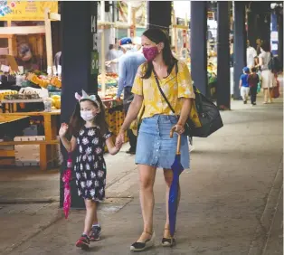  ?? ALLEN MCINNIS ?? Marie-helene Paquette and her daughter Romi walk the Atwater Market on Sunday. Starting today, Quebec will allow public gatherings of up to 250 people, an increase from 50 people.