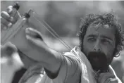  ?? — AFP ?? A Pakistani protester uses a slingshot to lob a stone towards the riot police in Islamabad on Sunday.