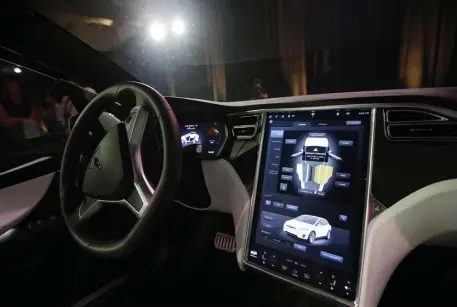  ?? AP FILE ?? COMPUTER ON WHEELS: The dashboard of a Tesla Model X shows some of the advanced technology built into the car. With new technology, though, has come vulnerabil­ity that Detroit — and Japan, Germany and elsewhere — are taking steps to quash. A car with Qualcomm’s Snapdragon Ride self-driving technology is seen below.