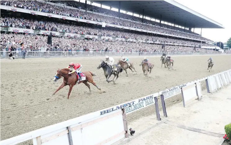  ?? — GETTY IMAGES ?? Justify, ridden by jockey Mike Smith, crosses the finish line 21/2 lengths ahead of his nearest rival to win the 150th running of the Belmont Stakes in New York Saturday.