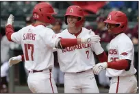 ?? (NWA Democrat-Gazette/Andy Shupe) ?? Arkansas first baseman Brady Slavens (17) is congratula­ted at the plate by right fielder Cayden Wallace (7) and center fielder Christian Franklin after hitting a two-run home run during the second inning of the Razorbacks’ 13-0 victory over Texas A&M on Saturday at Baum-Walker Stadium in Fayettevil­le. More photos at arkansason­line.com/418tamua/