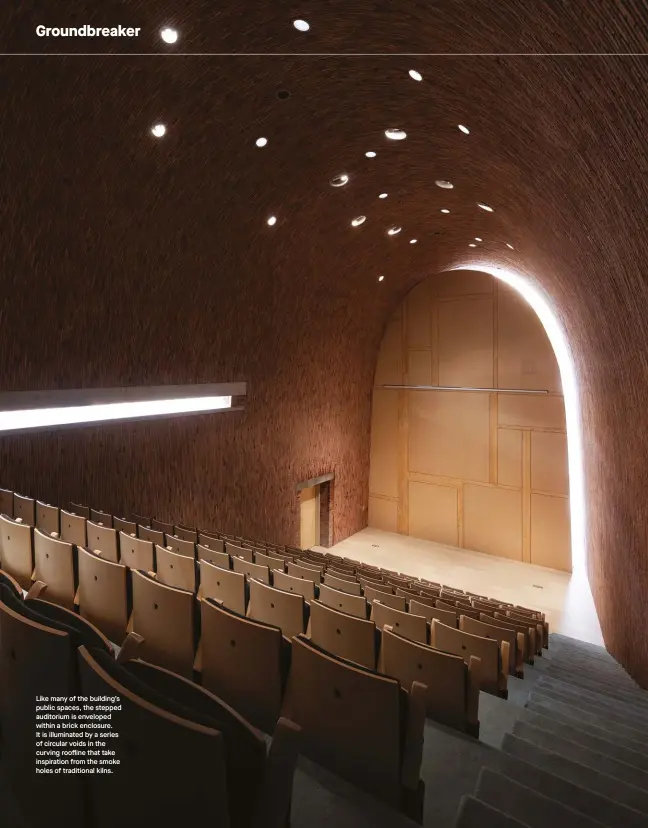  ??  ?? Like many of the building’s public spaces, the stepped auditorium is enveloped within a brick enclosure. It is illuminate­d by a series of circular voids in the curving roofline that take inspiratio­n from the smoke holes of traditiona­l kilns.