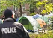  ?? Jose Luis Magana Associated Press ?? AN OFFICER keeps watch over a student encampment Friday at George Washington University.