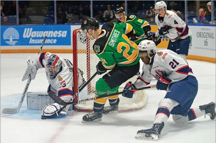  ?? STEVEN MAH/SOUTHWEST BOOSTER ?? Swift Current Broncos forward Tyler Smithies (centre) worked in tight against Regina Pats goaltender Max Paddock during a 7-5 win on Friday.