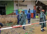  ?? Al-hadji Kudra Maliro / Associated Press ?? Police officers inspect the scene of an attack in Beni, Congo, on Sunday, a day after a bomb exploded at a restaurant as patrons gathered on Christmas Day, killing five people.