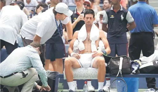  ?? — Gambar AFP ?? SUHU TINGGI: Djokovic meletakkan tuala ais selepas diberikan rehat selama 10 minit ketika beraksi menentang Fucsovics pada pusingan pertama Terbuka AS di New York, Amerika Syarikat Selasa lepas.