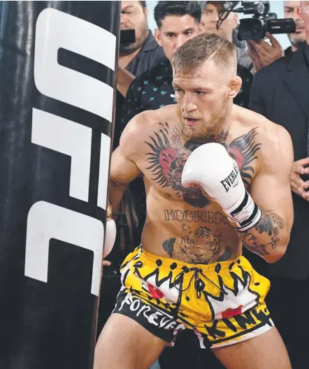  ?? Picture: AFP PHOTOS ?? Conor McGregor hits a heavy bag during a workout, but the UFC star must stick to boxing this weekend.