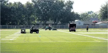  ?? LAURA BARTON/WELLAND TRIBUNE ?? Workers install the surface of Welland Centennial Secondary School’s new artificial turf field earlier this month. In addition to the field, the track surroundin­g it has also been replaced with artificial turf, and the project also includes new...