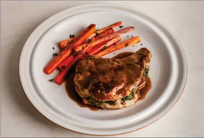  ?? Goran Kosanovic photo/food styling by Lisa Cherkasky for The Washington Post ?? Apple and Kale-Stuffed Pork Chops with Riesling Mustard Sauce.