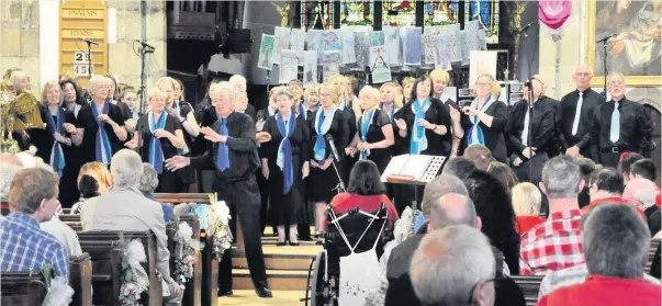  ??  ?? Harmonic Voices community choir directed by Steve Johnson (front, centre left) performed in a massed choral concert held in St Mary’s Church, Hinckley in recent times