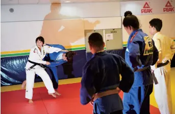  ??  ?? Yuko Fujii (left) gives a class to young students. As the first female head coach of the Brazilian men’s national team, Fujii throws gender barriers to the mat. — AFP