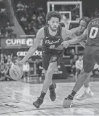  ?? DAVID REGINEK/USA TODAY SPORTS ?? Pistons guard Cade Cunningham (2) drives to the basket as center Jalen Duren (0) sets a pick on Pacers forward Aaron Nesmith.