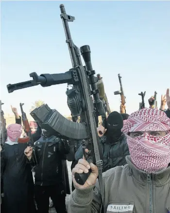  ?? The Associat ed Press ?? Masked gunmen in Fallujah chant slogans against Iraq’s Shiite-led government on Tuesday.