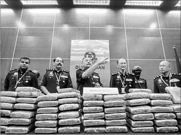  ??  ?? Mohd Mokhtar (centre) showing the 206 compressed slabs of ganja during the press conference. — Bernama photo