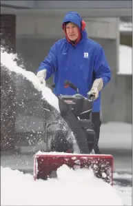  ??  ?? Mario Alberto uses a snowblower to clear snow from a driveway.