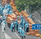  ?? AFP ?? Workers stack up boxes with food to deliver in a neighbourh­ood under lockdown in the Jing'an district in Shanghai.